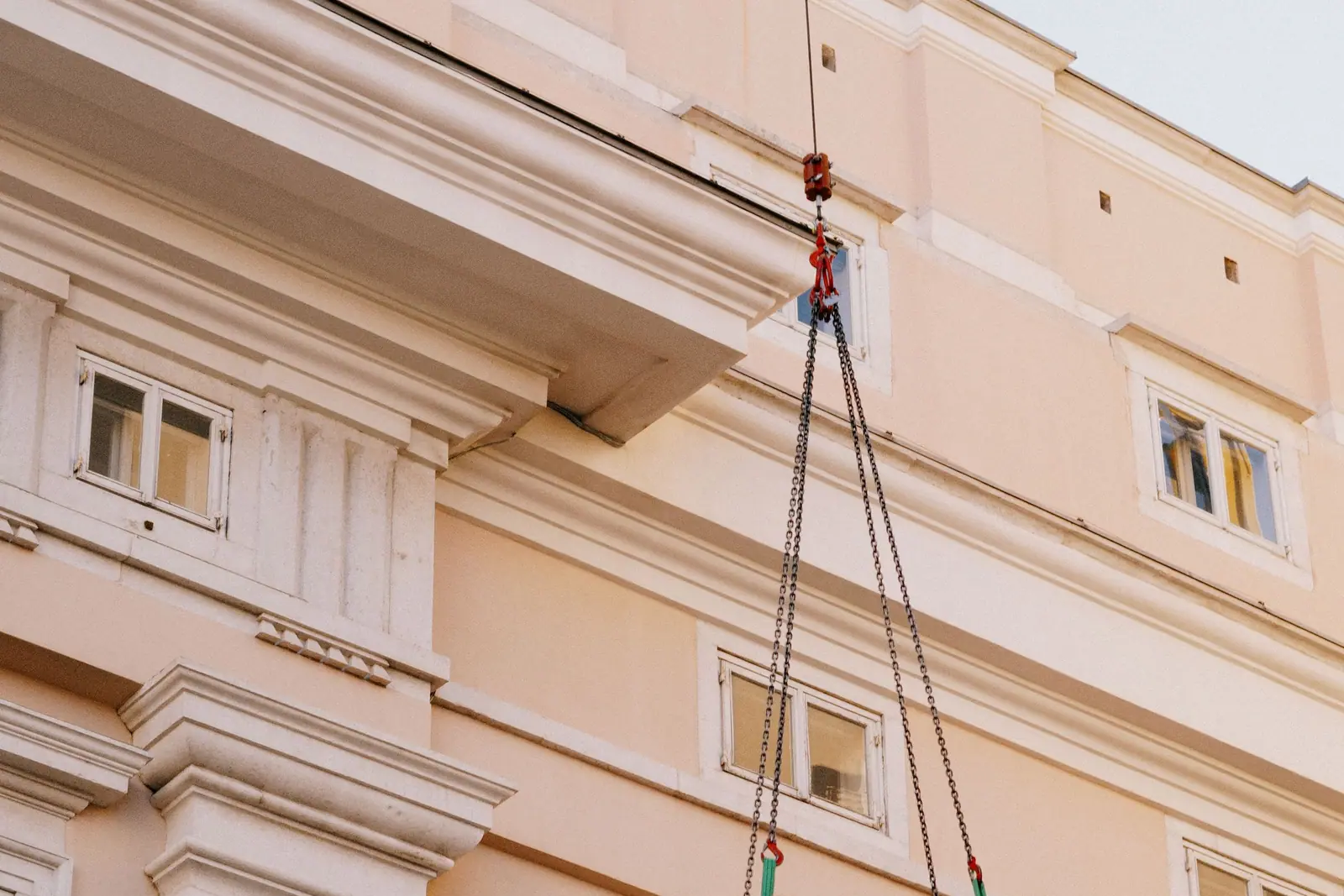 Load being hoisted up a building facade by rope