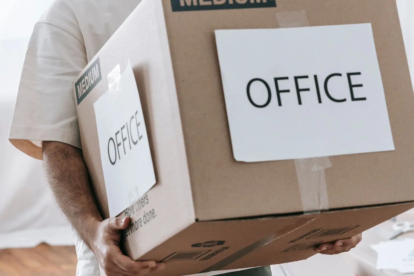 Hands carrying a box labeled for the office
