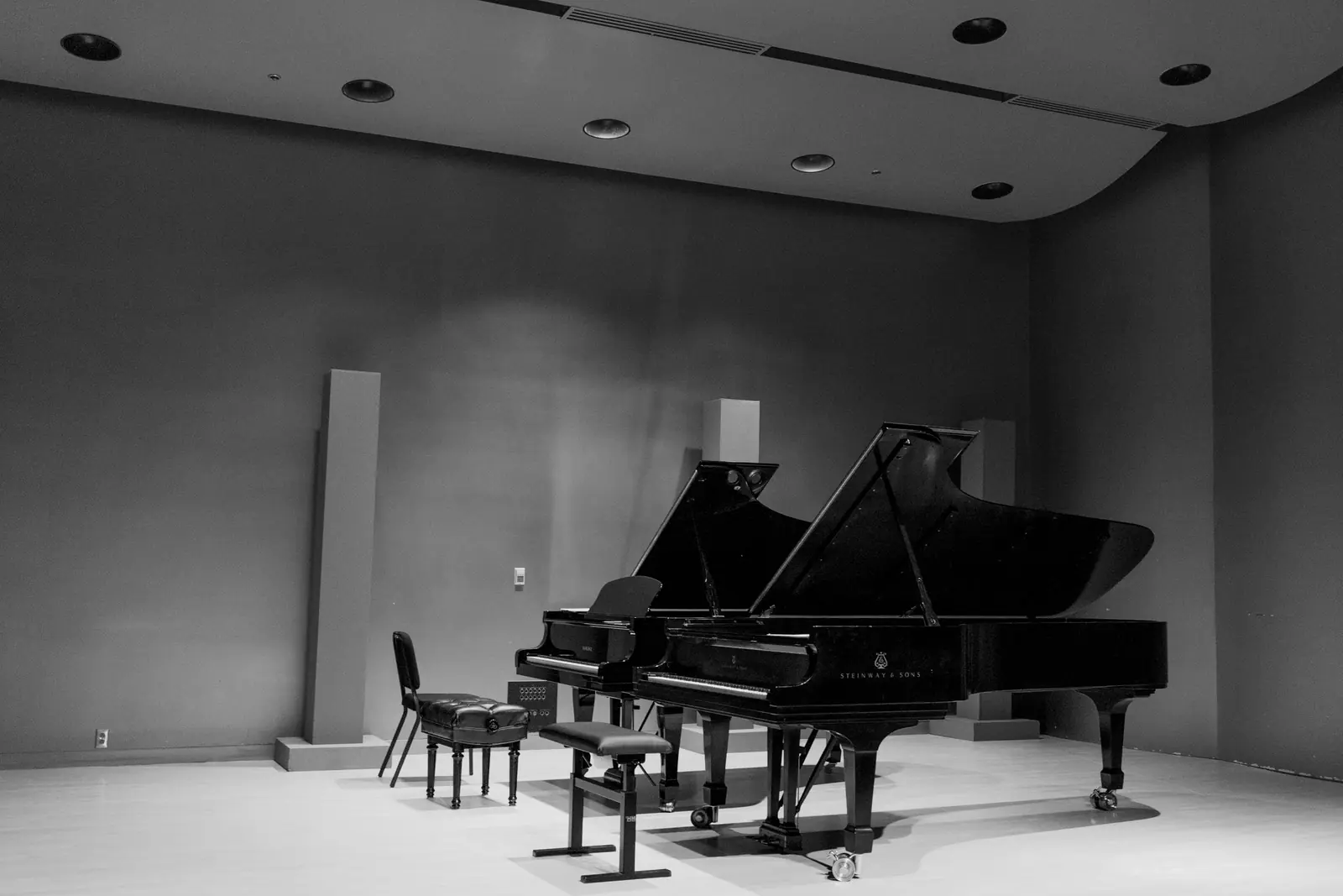 Two grand pianos in a white room