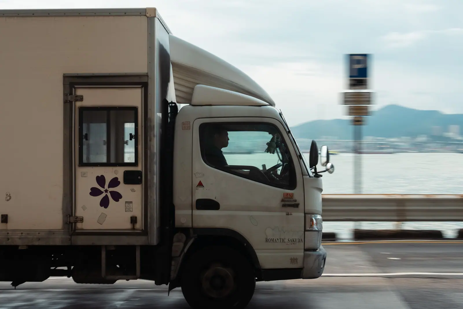 Box truck driving along a coastal road