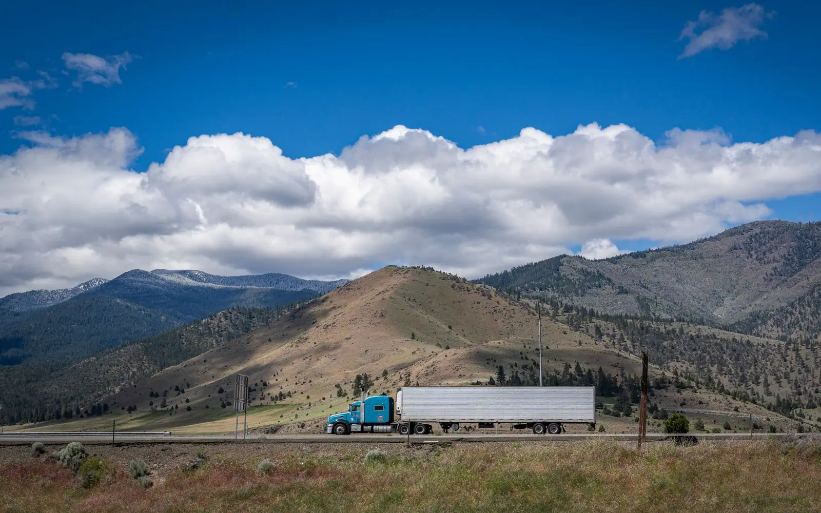 Long-haul truck on a highway in front of mountains