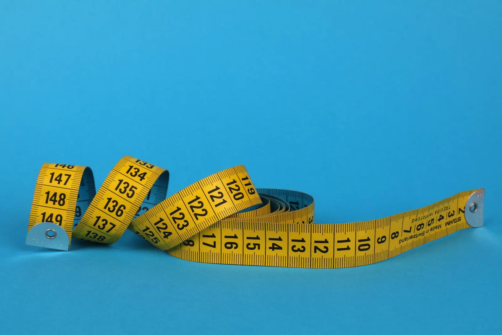 Yellow tape measure on a blue background